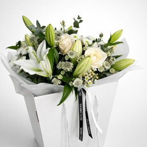White Symphony bouquet with white lilies and ivory roses in DV Flowers gift bag